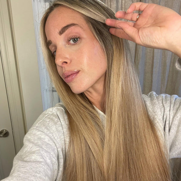 Woman with long, blonde hair who is using Act+Acre Oily Hair System