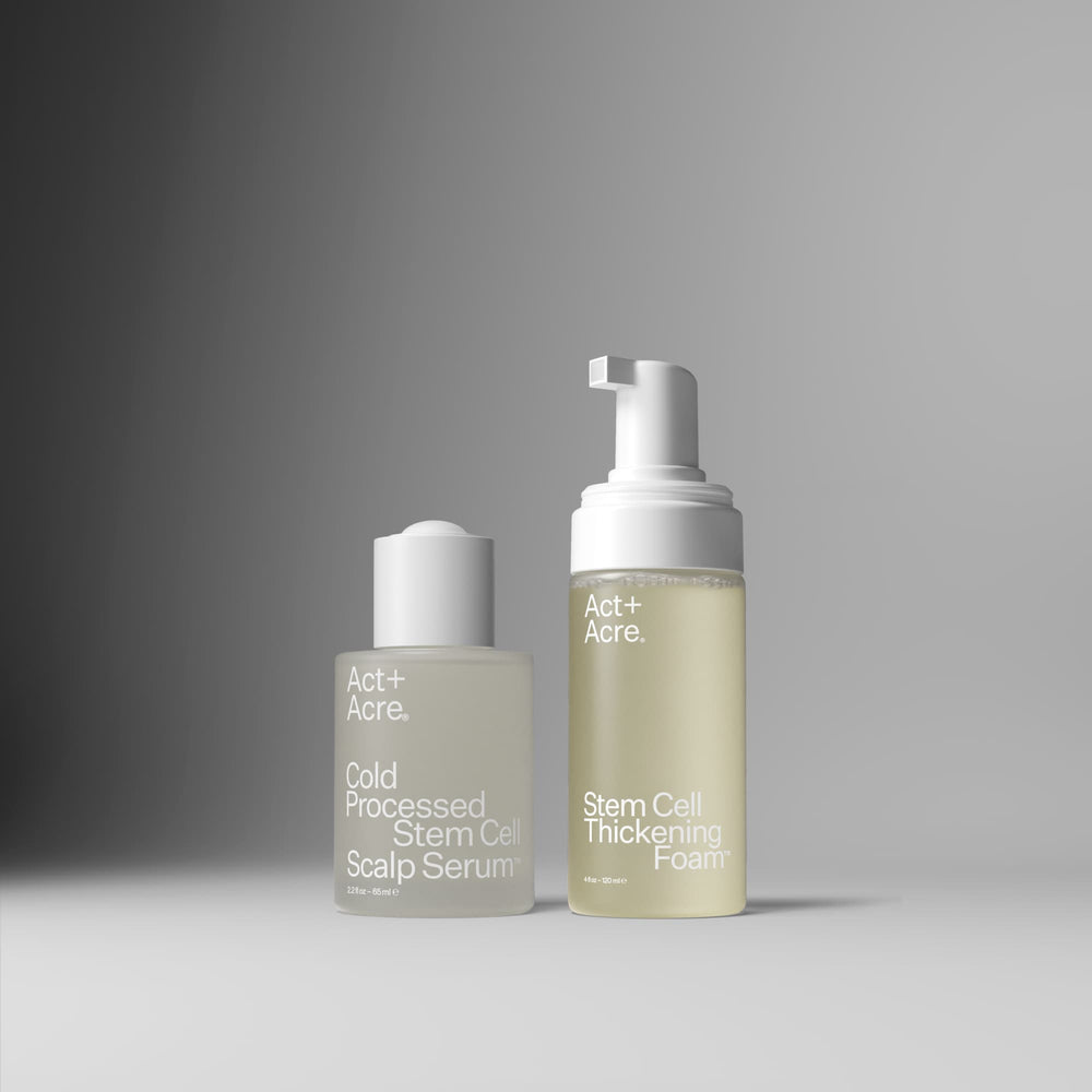 Two skincare bottles from Act+ Acre. on a gray gradient studio background.
