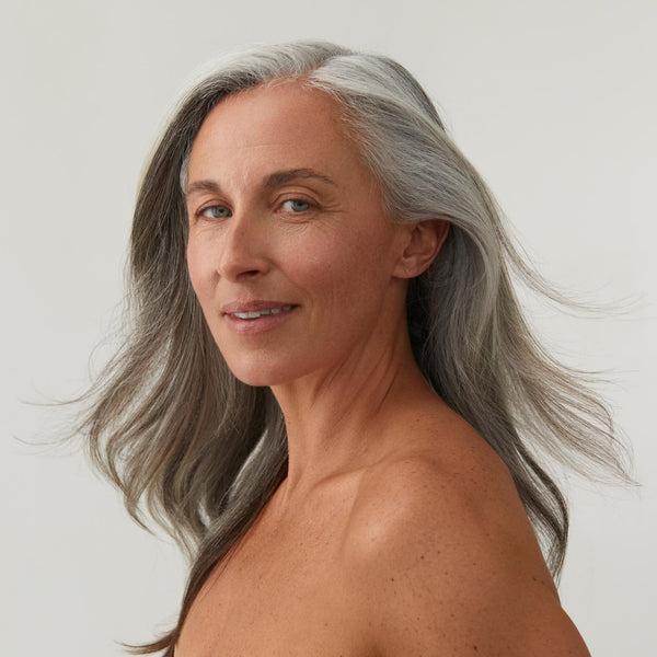 Woman smiling with long, grey hair 