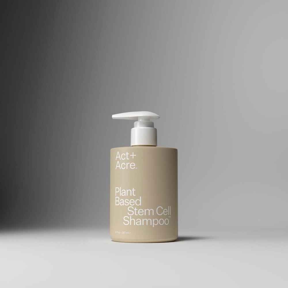 A bottle of Act+ Acro. Plant Based Stem Cell Shampoo in a beige container with a white pump dispenser, set against a dark-to-light gray gradient background.