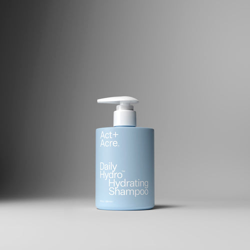 Blue shampoo bottle with pump on a gray background