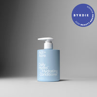 A bottle of Act+ Acre. Daily Hydro Hydrating Conditioner in a light blue bottle with a white pump dispenser, set against a dark-to-light gray gradient background.