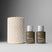 Two bottles of Act+Acre Cold Processed Hair Cleanse and Conditioner next to a textured beige container on a gray background.